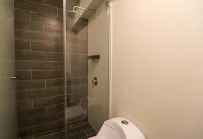a bathroom with a toilet and a glass shower at Soul by Wynwood House in Lima