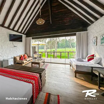 a bedroom with two beds and a living room at HOTEL RUSTICA CIENEGUILLA in Cieneguilla