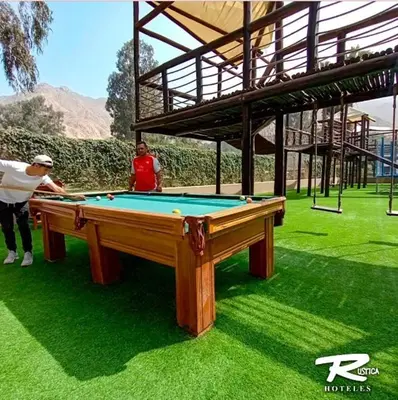 two people standing around a pool table on the grass at HOTEL RUSTICA CIENEGUILLA in Cieneguilla