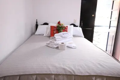 a bedroom with a bed with towels on it at Millas House Cusco in Cusco