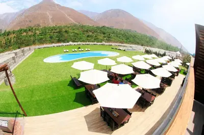 a group of tables with white umbrellas on a mountain at HOTEL RUSTICA SANTA EULALIA in Lima