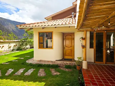 a house with a door and a grass yard at Hotel and Country House Valle Sagrado de los Incas in Huaran
