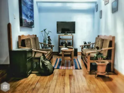 a living room with two chairs and a flat screen tv at OkiDoki Cusco Hostal in Cusco