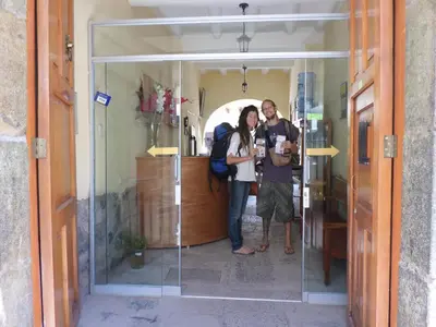 a group of three people standing in a glass doorway at OkiDoki Cusco Hostal in Cusco