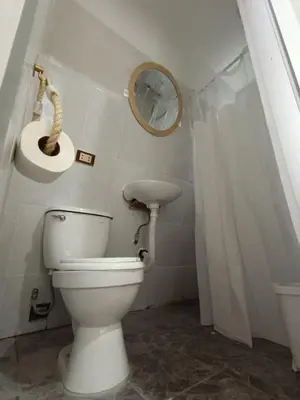 a bathroom with a white toilet and a sink at Vallecito Lodge in Muyurina