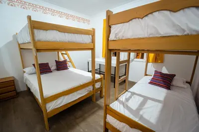 a room with two bunk beds and a desk at Casa Águila y Cóndor Miraflores in Lima