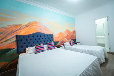 two beds in a room with a painting on the wall at Casa Águila y Cóndor Miraflores in Lima