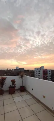 a balcony with potted plants and a cloudy sky at Sumaq Home Lima Airport in Lima