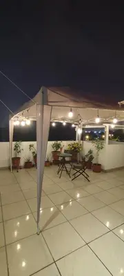 a white tent with lights on a patio at night at Sumaq Home Lima Airport in Lima