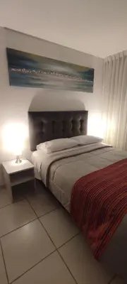a bedroom with a large bed and a lamp at Sumaq AirPort in Lima