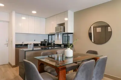 a kitchen and dining room with a table and chairs at One By Wynwood House in Lima