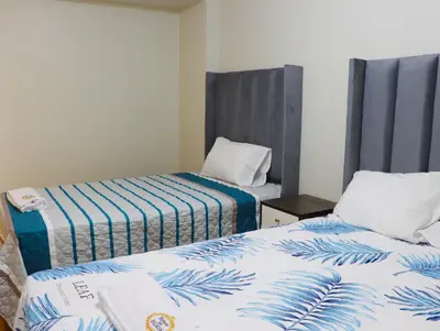 a room with two beds with blue and white sheets at Paloma House in Lima