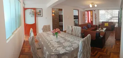 a dining room with a table with a vase of flowers on it at WaskarWasi in Cusco