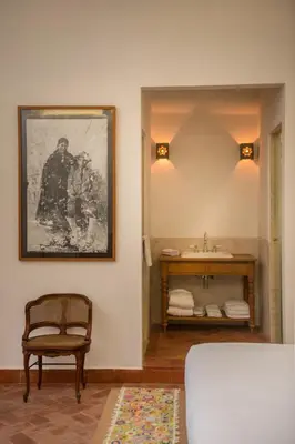 a bathroom with a sink and a bed and a chair at Casa Clara by Ananay Hotels in Cusco