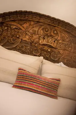 a wooden head board with a pillow on a bed at Casa Clara by Ananay Hotels in Cusco