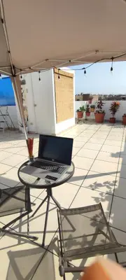 a laptop sitting on a table on a patio at Lima Airport Sumaq Home in Lima