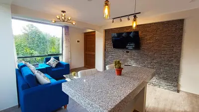 a living room with a blue couch and a table at PACHAMAMA APARTMENt in Urubamba