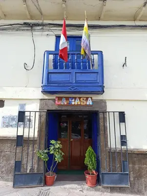 a building with two flags in front of a restaurant at HOSTAL La RASA in Cusco