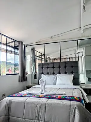 a bedroom with a large bed and a large window at HOSTAL La RASA in Cusco
