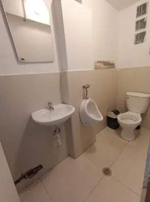 a bathroom with a toilet and a sink and a urinal at HOSTAL La RASA in Cusco