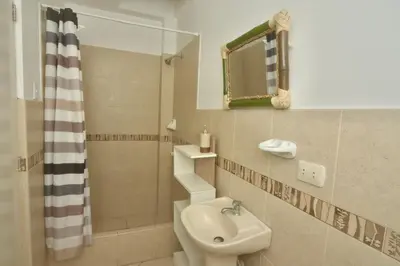 a bathroom with a sink and a toilet and a shower at Casa mar surfhouse in Punta Hermosa