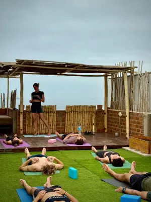 a group of people doing yoga on the grass at Casa mar surfhouse in Punta Hermosa