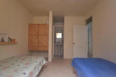 a bedroom with a bed and a bathroom at Casa mar surfhouse in Punta Hermosa