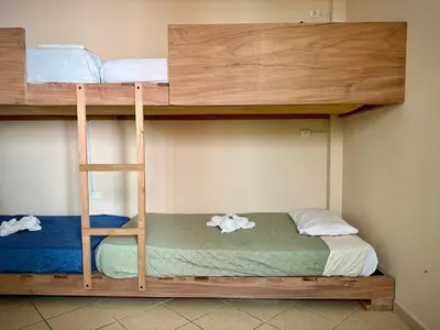 two bunk beds in a room with a ladder at Casa mar surfhouse in Punta Hermosa