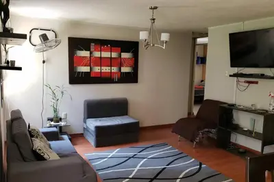 a living room with a couch and a tv at Amplio, y confortable departamento en San Miguel in Lima