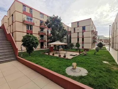 an apartment complex with a lawn in front of a building at Amplio, y confortable departamento en San Miguel in Lima