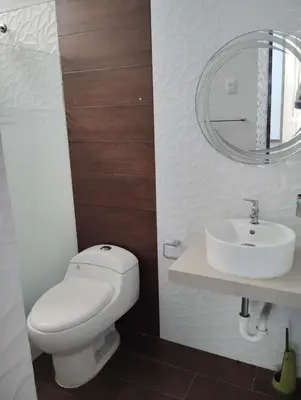 a bathroom with a white toilet and a sink at CASITA PARA FIN DE SEMANA in Chincha Baja