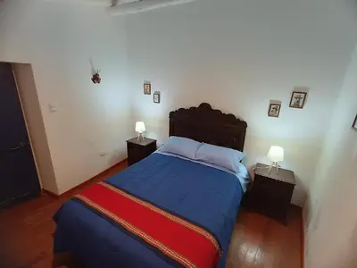 a bedroom with a blue bed with two night stands at Mini Apart II - Sumaq Wasi ALBA in Cusco
