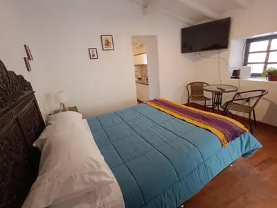 a bedroom with a bed with a blue blanket at Mini Apart II - Sumaq Wasi ALBA in Cusco