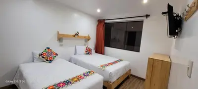 a small room with two beds and a television at Hotel Ruta Amazónica Machupicchu in Machu Picchu