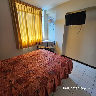 a bedroom with a bed and a flat screen tv at Hostal La Cascada in Lima