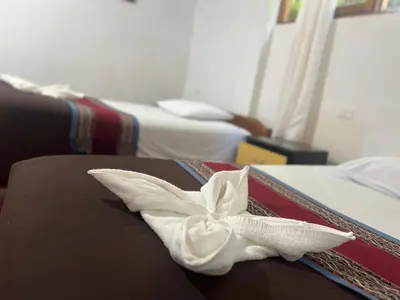 a white flower on a bed in a hotel room at Eco Inca Trail Lodge Lucmabamba in Cusco