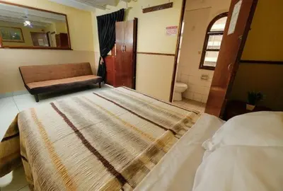 a bedroom with a large bed and a bathroom at Residencial San Felipe in Lima