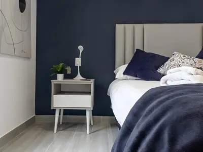 a bedroom with a bed and a night stand with a plant at Moderno 2BR Center Miraflores- Balta 301 in Lima