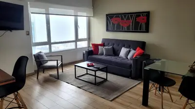 a living room with a blue couch and a table at Acogedor 2BR Miraflores - Tovar in Lima