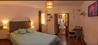 a bedroom with a bed and a chair in it at Apu House Minidepartamento in Cusco