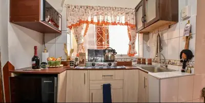 a kitchen with a stove and a sink and a window at Apu House Minidepartamento in Cusco