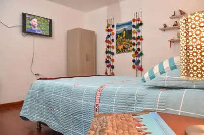 a bedroom with a bed with a blue comforter at Apu House Minidepartamento in Cusco