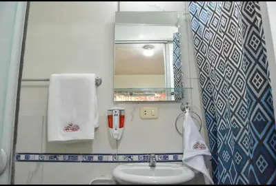 a small bathroom with a sink and a mirror at Apu House Minidepartamento in Cusco