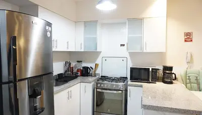 a kitchen with white cabinets and a stainless steel refrigerator at APARTAMENTOS PRIVADOS Lima Airport Perú in Lima