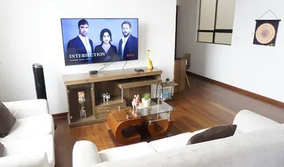 a living room with a tv and a table at APARTAMENTOS PRIVADOS Lima Airport Perú in Lima