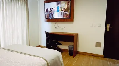 a bedroom with a piano and a tv on the wall at Casa Pucllana Miraflores - Hotel Boutique in Lima