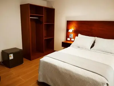 a bedroom with a large bed with a wooden headboard at Casa Pucllana Miraflores - Hotel Boutique in Lima