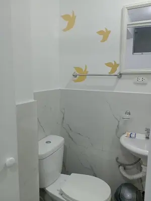 a white bathroom with a toilet and a sink at Puerta Azul Hospedaje in Lima