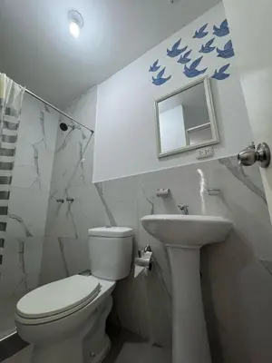 a bathroom with a toilet and a sink and a mirror at Puerta Azul Hospedaje in Lima