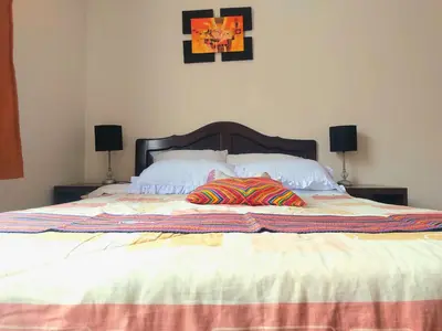 a large bed with two pillows on top of it at Sumaq Wasi Caminos Del Inca in Lima